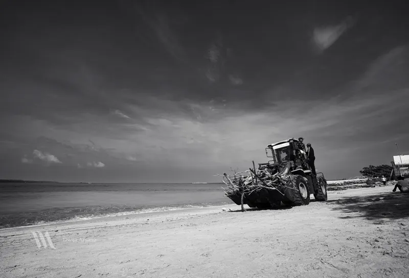 Foto ekskavator sedang beroperasi mengangkut sampah potongan kayu